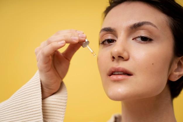 woman applying facial serum skincare product