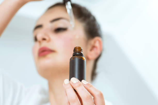 Woman applying serum to face with dropper